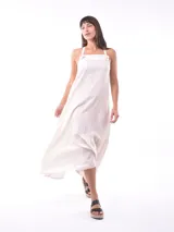 Vestido largo color crudo, con breteles finos y volados en el ruedo.