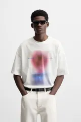 Camiseta blanca de corte relaxed fit, cuello redondo y manga corta. Estampado combinado a contraste en el delantero con imagen borrosa de flor y texto en azul.