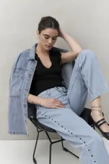 Pantalón jean celeste de corte recto, con apliques metálicos en los laterales.