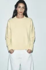 Jersey color amarillo pastel de punto liso, con cuello redondo y manga larga.