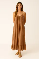Vestido largo de breteles finos ajustables, color marrón, con escote redondo y cuerpo fruncido con caída amplia.
