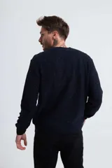 Sweater de punto trenzado color azul marino, con cuello redondo y mangas largas.