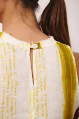 Vestido corto sin mangas, con cuello redondo y estampado a rayas verticales en tonos blanco y amarillo. Confeccionado en lino italiano y detalle desflecado en cuello y ruedo.