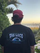 Gorra de béisbol color rojo vino con visera curva. Estampado frontal con un corazón y el texto "LOVE & PEACE" en blanco, y debajo "PP-ONE".