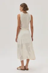 Falda midi color crudo, tejida de punto calado con diseño de flores. Cuenta con elástico y lurex en la cintura.