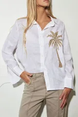 Camisa blanca de lino con bordado de una palmera en el pecho.