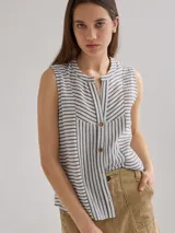 Camisa sin mangas con cuello mao y cierre frontal con botones. Diseño a rayas verticales en blanco y gris.