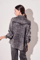 Camisa de denim de corte al cuerpo, con dos bolsillos frontales y cierre de botones.