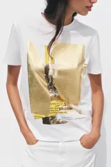 Camiseta blanca de manga corta y cuello redondo con estampado metalizado en el frente.