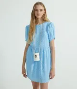 Vestido corto celeste con textura de poliéster, cuello redondo, mangas cortas abullonadas y falda fruncida.