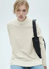 Sweater azul marino de punto fino con cuello perkins, corte oversize y mangas largas.