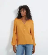 Blusa color mostaza de manga larga abullonada, con escote en V y botones en el frente.
