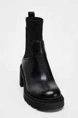 Botín Chelsea negro de cuero con caña de neopreno, tacón bloque y suela track.