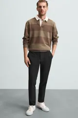 Pantalón largo de vestir gris claro con estampado de cuadros, corte slim fit y cintura elástica. Confeccionado en tejido con alta elasticidad, bolsillos frontales y cierre frontal con cremallera y botón.