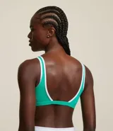 Top deportivo color marrón con breteles anchos y doble tira, copa desmontable, detalles contrastantes en color crema, escote en U delantero y escote en V en la espalda. Confeccionado en microfibra.