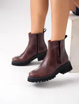 Botas Chelsea de cuero vacuno negro con elásticos laterales, cierre interno y suela de goma artesanal.