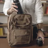 Mochila marrón de tela canvas con compartimento para notebook y accesorios de mate.