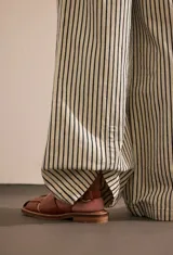 Pantalón de algodón a rayas verticales blancas y negras, de corte amplio y cintura alta con cordón ajustable.