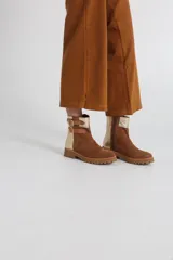 Botas cortas de gamuza color marrón con detalles dorados y hebillas decorativas.