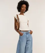 Pantalón de jeans celeste marmolado, corte barrel, con trabillas en la cintura, bolsillos delanteros y traseros, y detalle de recortes en las rodillas.