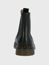 Botín chelsea negro de cuero con elásticos laterales, suela de goma gruesa y pespuntes amarillos alrededor de la suela. Tiene una tira trasera para facilitar el calce.