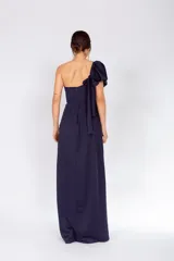 Vestido largo color salmón de un solo hombro, con manga corta abullonada y falda con abertura lateral y volados.
