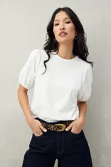Remera blanca de algodón con mangas abullonadas y elástico en la terminación.