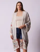 Cardigan largo color crema, de gasa bordada con motivos florales en mangas y ruedo.