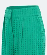 Pantalón recto verde esmeralda de laise con cintura mediana, bolsillos laterales, pliegues frontales y textura con pequeños agujeros.
