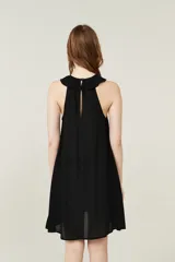 Vestido corto negro con cuello halter y volados.