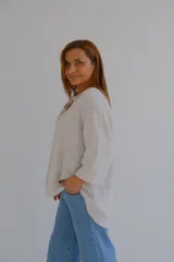Blusa de manga 3/4 con cuello en V y estampado a rayas verticales en tonos beige y blanco.