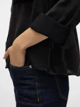 Camisa negra de corte clásico con cuello, manga larga y bolsillos en el pecho.