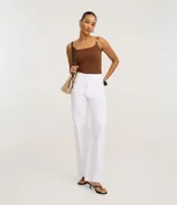 Body femenino color marrón oscuro, ajustado, con escote en U y tirantes dobles finos. Los tirantes tienen un adorno tipo cuenta de carey. El tejido es texturizado.