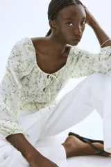 Blusa corta blanca con estampado floral, de tejido arrugado, escote cuadrado elástico con cordón ajustable, mangas globo largas con puños elásticos y costuras elásticas en la cintura para un efecto fruncido.
