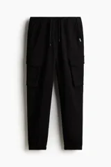 Pantalón jogger negro de felpa pesada de mezcla de algodón, corte slim fit, con cintura elástica ajustable con cordón, cierre decorativo, bolsillos al bies, bolsillo trasero y bolsillos cargo con solapa y botones a presión ocultos en las piernas.