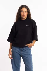 Remera negra de corte cuadrado con cuello alto y mangas cortas anchas. Estampado pequeño con el logo de la marca en el pecho.
