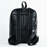 Mochila negra de cuero sintético con diseño acolchado en forma de hexágonos, cierre superior y bolsillo frontal con cierre.