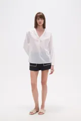 Blusa de algodón color menta, con escote en V, mangas largas y detalles de bordado floral y mostacillas en los hombros y el escote.