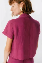 Camisa celeste de lino con cuello clásico, mangas cortas, corte crop y lazos en el frente.