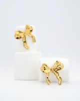 Par de aros tipo stud dorados con forma de lazo.