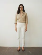 Pantalón tipo jegging de denim color blanco roto, tiro alto, corte recto al tobillo con cierre funcional en el ruedo. Diseño pull-on sin cierre ni botón frontal, con bolsillos funcionales traseros y simulados delanteros.