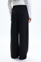 Pantalón deportivo negro de tiro alto, corte ancho y pierna recta, con bolsillos laterales.