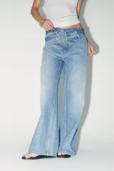Pantalón de jean celeste de tiro alto, corte wide leg y largo hasta el tobillo. Incluye cinturón de la misma tela con trabillas y cierre frontal con cremallera, botón y gancho metálico.