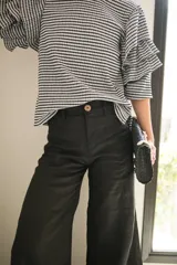 Pantalón negro de lino, corte wide leg y tiro medio.