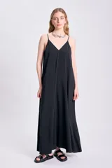 Vestido largo negro con breteles finos y escote en V, de corte amplio y estilo minimalista.