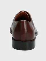 Zapato de vestir formal de cuero color marrón con cordones.