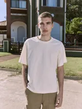 Remera color crema de manga corta y cuello redondo con estampa en la espalda con la palabra "MALIBU".