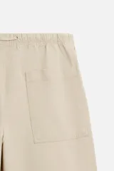 Pantalón de hombre color beige, corte carrot fit, con cintura elástica ajustable con cordón, bolsillos frontales y bolsillo trasero de plastrón.