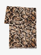 Bufanda rectangular con estampado de manchas tipo animal print en tonos marrón, beige y negro. Tiene flecos pequeños en los extremos.