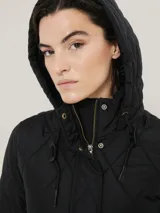 Campera negra acolchada de Tommy Hilfiger con cierre de cremallera, cuello alto con capucha, mangas largas y bolsillos laterales con cremallera.